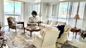 Tiled living room with healthy amount of natural light, a textured ceiling, and expansive windows