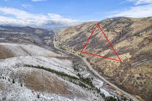 Snowy aerial view with a mountain view and property boundaries highlighted