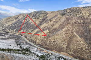 Aerial overview of property's location featuring a mountain backdrop and property parcel outlined