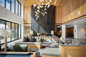 Common area with wooden walls, a towering ceiling, and wooden ceiling
