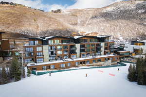 Snow covered building with a view of apartment building / complex and a mountain view