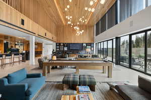 Common area featuring wood walls, a towering ceiling, and wooden ceiling