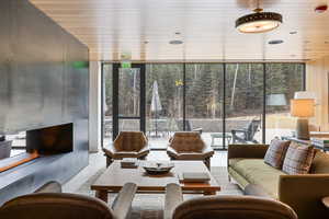 Living area featuring floor to ceiling windows, light tile patterned floors, and wood ceiling