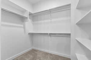 Walk in closet with light carpet