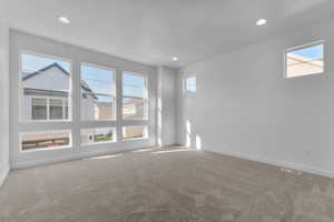 Carpeted spare room featuring healthy amount of natural light and recessed lighting