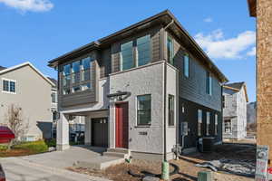 Contemporary home with concrete driveway, brick siding, and a garage