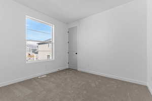 Empty room featuring carpet floors and baseboards