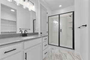 Full bath featuring vanity, a stall shower, recessed lighting, and a walk in closet