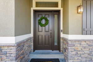 Entrance to property with stone siding and stucco siding