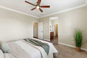 Bedroom featuring crown molding, light colored carpet, a ceiling fan, and connected bathroom