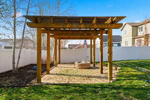 Fenced backyard featuring a pergola, a patio, and a fire pit
