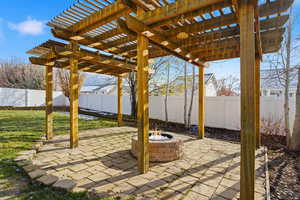 Fenced backyard featuring a fire pit, a patio area, and a pergola
