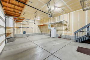 Garage with freestanding refrigerator and a garage door opener