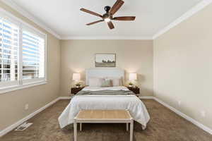 Bedroom with ornamental molding, carpet, and ceiling fan