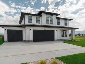View of front of house featuring a front lawn, concrete driveway, and a mountain view