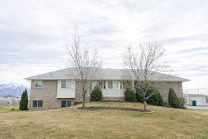 View of front of home featuring brick siding, a front lawn, and a mountain view