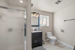 Full bathroom featuring vanity, a shower stall, and light wood finished floors