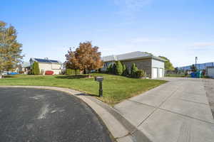 View of front of house with a garage, concrete driveway, and brick siding