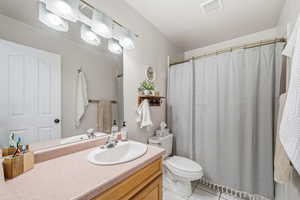 Bathroom featuring curtained shower, vanity, and light tile patterned flooring