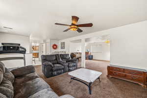 Carpeted living area featuring ceiling fan