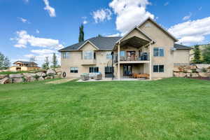 Rear view of property featuring an outdoor hangout area, a patio area, stucco siding, and a balcony
