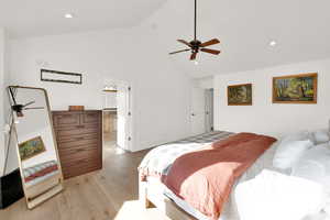 Bedroom with wood-type flooring, high vaulted ceiling, ceiling fan, and recessed lighting