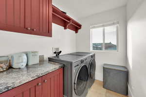 Laundry room with washer and clothes dryer and cabinet space