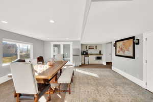 Dining space with light carpet, french doors, and recessed lighting