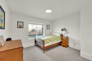 Bedroom with light carpet and baseboards