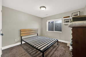 Bedroom featuring dark colored carpet