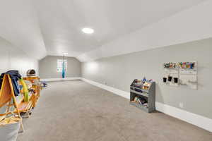 Playroom with carpet and vaulted ceiling