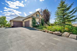 View of front of property featuring asphalt driveway, an attached garage, stucco siding, and a shingled roof
