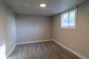 Empty room featuring baseboards and carpet