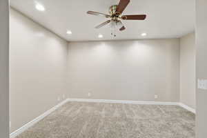 Spare room featuring carpet flooring, a ceiling fan, and recessed lighting