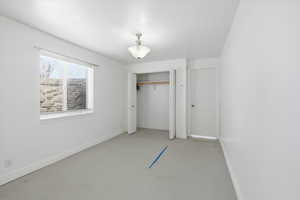 Unfurnished bedroom with a closet and concrete floors