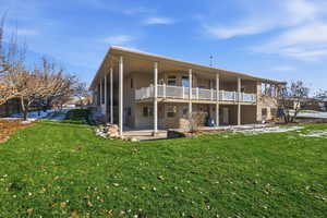 Rear view of property with a patio and a lawn
