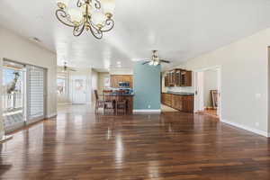 Living room featuring ceiling fan, dark wood-style flooring, a chandelier, and recessed lighting