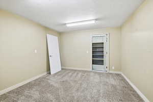 Empty room featuring carpet flooring and a textured ceiling