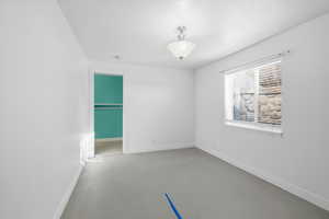 Unfurnished bedroom with baseboards and finished concrete floors