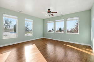 Empty room with hardwood / wood-style floors and a ceiling fan