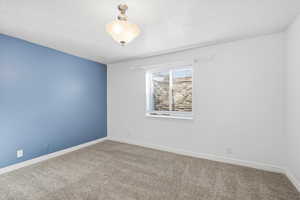 Carpeted spare room with baseboards