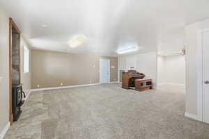 Unfurnished living room with baseboards and light carpet