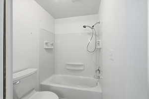 Bathroom with shower / bath combination and a textured ceiling