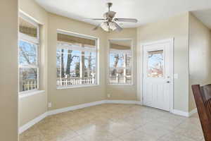 Foyer entrance featuring a ceiling fan and light tile patterned flooring