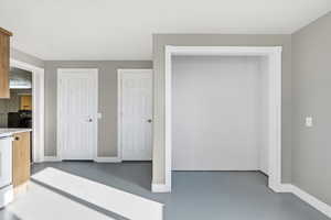 Kitchen featuring finished concrete flooring and white range with electric cooktop