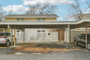 View of front of house featuring covered parking and roof with shingles