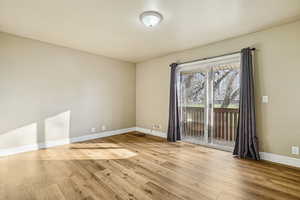 Unfurnished room with light wood finished floors and baseboards