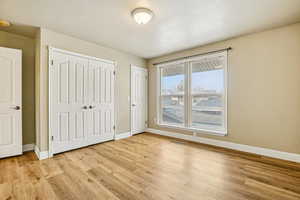 Unfurnished bedroom featuring light wood-style floors and baseboards
