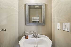 Bathroom with a sink and a textured wall