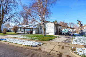 View of front of house with concrete driveway, a carport, and a residential view